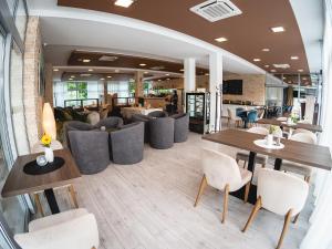 un restaurante con sofás, mesas y sillas en Hotel River, en Nitra