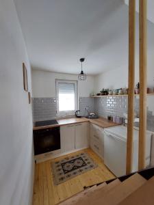 a kitchen with white cabinets and a window at Planinska kuca Bjelasnica in Sinanovići