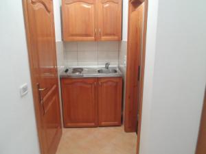 乌尔齐尼Apartments Kepi Gjerana的一个带木制橱柜和水槽的小厨房