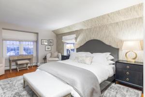 una camera con un grande letto bianco e una sedia di The Hermitage Inn Vermont a West Dover