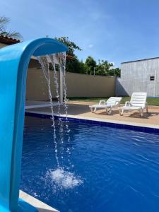 uma piscina com uma fonte de água num quintal em Dunas residence casa 03 em Santo Amaro