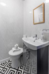 La salle de bains blanche est pourvue d'un lavabo et de toilettes. dans l'établissement City Centre Studio 7 with Kitchenette, Free Wifi and Smart TV by Yoko Property, à Middlesbrough