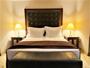 a bedroom with a large bed with two lamps at Maxi Park Hotel & Spa in Velingrad