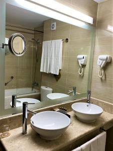 ein Badezimmer mit zwei Waschbecken und einem großen Spiegel in der Unterkunft Maxi Park Hotel & Spa in Welingrad