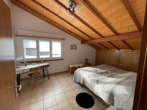 a bedroom with a bed and a desk in a room at Appart sympa ! in Sonceboz