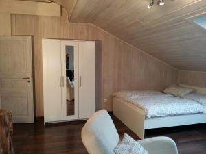 1 dormitorio con 1 cama y 1 silla en una habitación en Modernes Apartment zum Wohlfühlen, en Kolbermoor