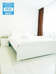 ein weißes Bett mit 2 Waschbecken in einem Zimmer in der Unterkunft Smart Apartament in Piatra Neamţ