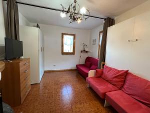 a living room with a red couch and a tv at Campo Felice Suite in Rocca di Cambio