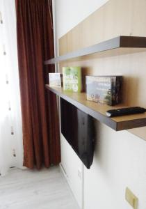ein Regal an einer Wand mit einem TV in einem Zimmer in der Unterkunft Smart Apartament in Piatra Neamţ