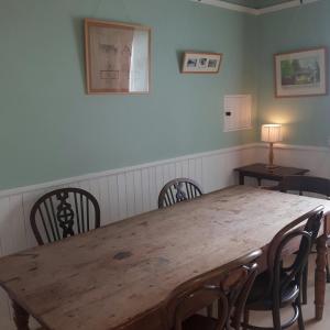 a wooden table and chairs in a room at Auchencairn Cottage in Brora