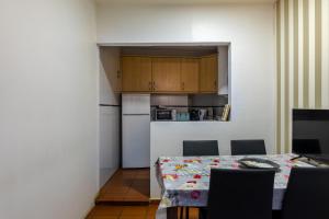 a kitchen with a table and a kitchen with a refrigerator at Casa da Avó Alsira 2 in Évora