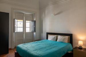 1 dormitorio con 1 cama con edredón azul en Casa da Avó Alsira 2, en Évora