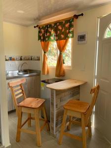 cocina con 2 sillas, mesa y fregadero en Cabaña campestre cerca a Ecoparque El Salado, Envigado., en Envigado