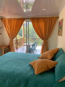 a bedroom with a green bed with curtains and a balcony at Cabaña campestre cerca a Ecoparque El Salado, Envigado. in Envigado