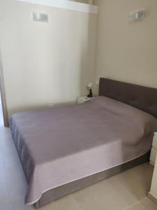 Una cama en un dormitorio con una manta morada. en Appartamento via giansanti en Terracina