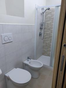 Appartamento via giansanti في تيراتشينا: حمام ابيض مع مرحاض ودش
