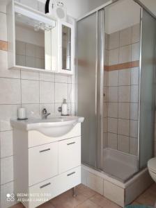 a white bathroom with a sink and a shower at Apartments Golić in Biograd na Moru +95 photos