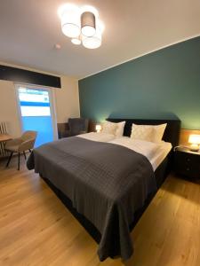 a bedroom with a bed and a chair and a window at Hotel Schütz in Trier