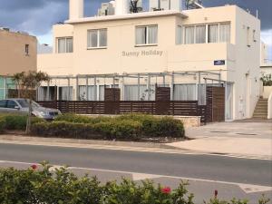 a large white building with a sign on it at Sunny holiday by konnos in Paralimni