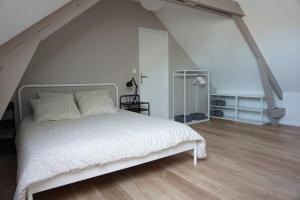 - une chambre avec un lit blanc et du parquet dans l'établissement L'Escapade - Maison - Spacieuse - Jardin - Plage, à Zuydcoote