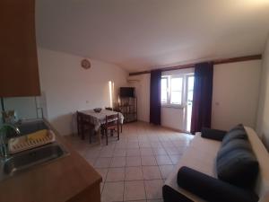 a living room with a couch and a table at Apartments Donadic I, Caska in Novalja