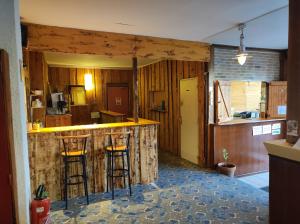 a kitchen with a counter and stools at a bar at Auberge de Jeunesse HI Chamrousse in Chamrousse
