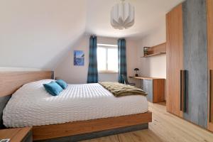- une chambre avec un lit king-size et des oreillers bleus dans l'établissement Gîte Les terrasses du Mambourg à Kaysersberg-Vignoble, à Kaysersberg