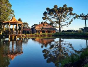 a building with a gazebo next to a lake at Pousada Rural Vista Alegre in Bom Jardim da Serra