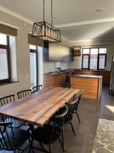 a kitchen and dining room with a wooden table and chairs at Qabala Lux Villa in Gabala
