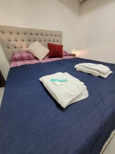 a blue bed with white towels on top of it at Mio Amore Tigre - C in Tigre