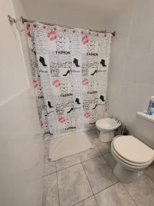 a bathroom with a toilet and a shower curtain at Mio Amore Tigre - C in Tigre