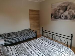 ein Schlafzimmer mit 2 Betten und einem Wandgemälde in der Unterkunft Gîte Savane près de Pairi Daiza in Brugelette