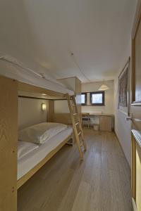 ein Schlafzimmer mit einem Etagenbett und einer Leiter in der Unterkunft Chesa Chavriol - Celerina in Celerina