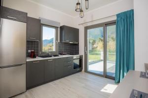 a kitchen with gray cabinets and a large window at Apollonian Luxury Apartments in Vasiliki