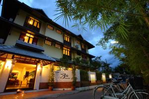 un bâtiment avec un vélo garé devant lui dans l'établissement The 3sis Hotel, à Chiang Mai