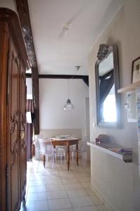 a dining room with a table and chairs and a mirror at Gite de l'Oncle Hansi in Colmar