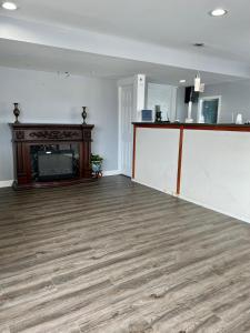 an empty living room with a fireplace and wooden floors at Knights Inn Madison Heights in Madison Heights