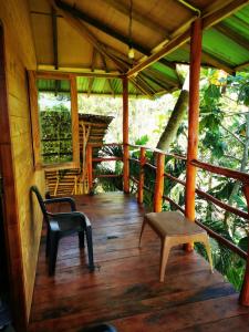 um alpendre de uma cabina com um banco e uma mesa em Lake Paradise Cabana em Tissamaharama