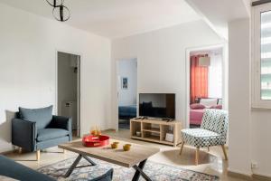 uma sala de estar com um sofá e uma televisão em Brand New Bright modern 6bdr apt-1min to Acropolis em Atenas