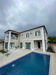 a house with a swimming pool in front of it at Qabala Lux Villa in Gabala