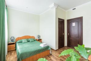 een slaapkamer met een bed en een houten vloer bij Mini Hotel on Saydasheva in Kazan