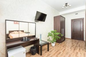 a bedroom with a bed and a desk with a mirror at Mini Hotel on Saydasheva in Kazan