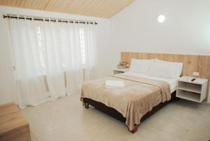 1 dormitorio con 1 cama con sábanas blancas y ventana en Casa LOURDES, en Valledupar 37 fotos más
