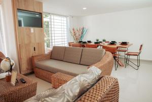 Una sala de estar con un sofá y un comedor. en Casa LOURDES, en Valledupar