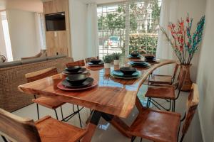 uma sala de jantar com uma mesa de madeira e cadeiras em Casa LOURDES em Valledupar