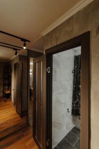 a hallway with a glass door leading into a room at Квартира студия в центре Великий Гэтсби in Petropavlovsk