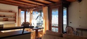 a living room with a couch and a large window at il Maso in Val di Sole in Commezzadura