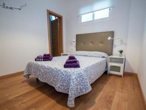 um quarto com uma cama com toalhas roxas em VV La Hoya El Diablo em Jerez de la Frontera