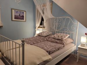 1 dormitorio con 1 cama blanca con dosel en In der alten Gärtnerei B&B, en Neuhof an der Zenn