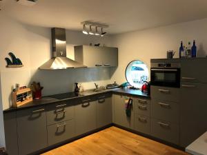 a kitchen with stainless steel appliances and a window at Maison entre forêt et océan - Lacanau Océan in Lacanau-Océan